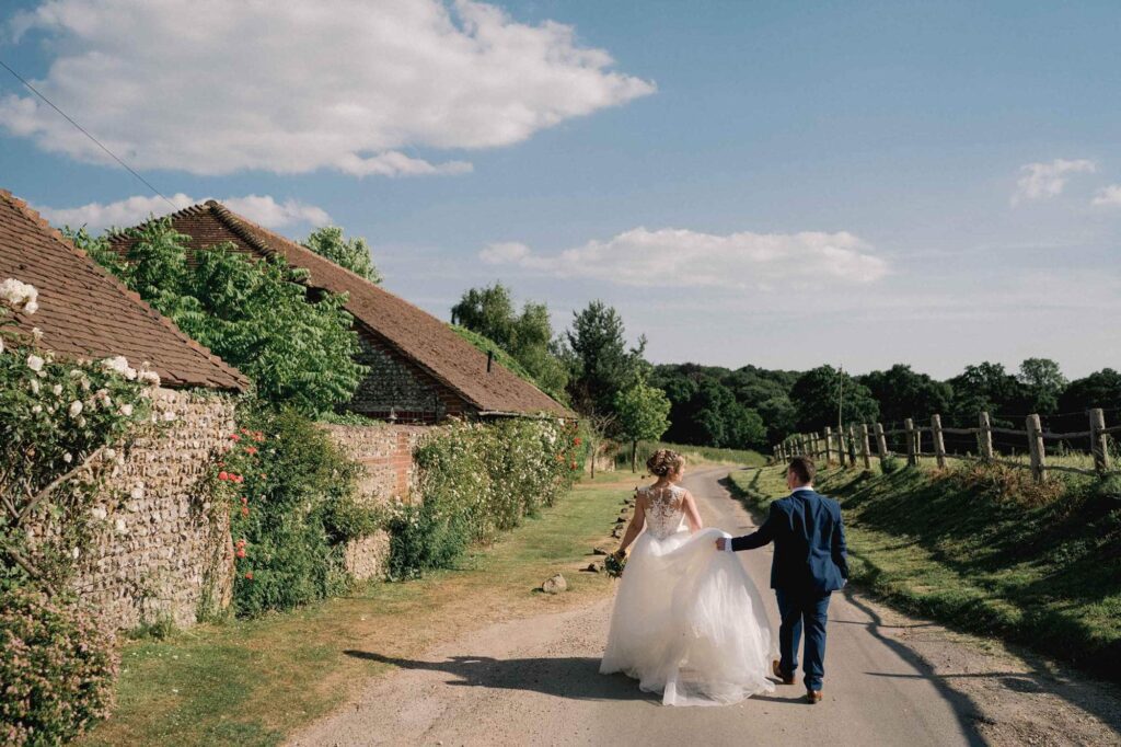 Bride and groom smiling whilst they take a stroll on their wedding day in East Grinstead.