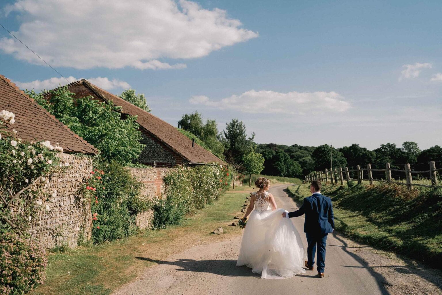 Bride and groom walking in the lane outside Selden barn wedding venue.