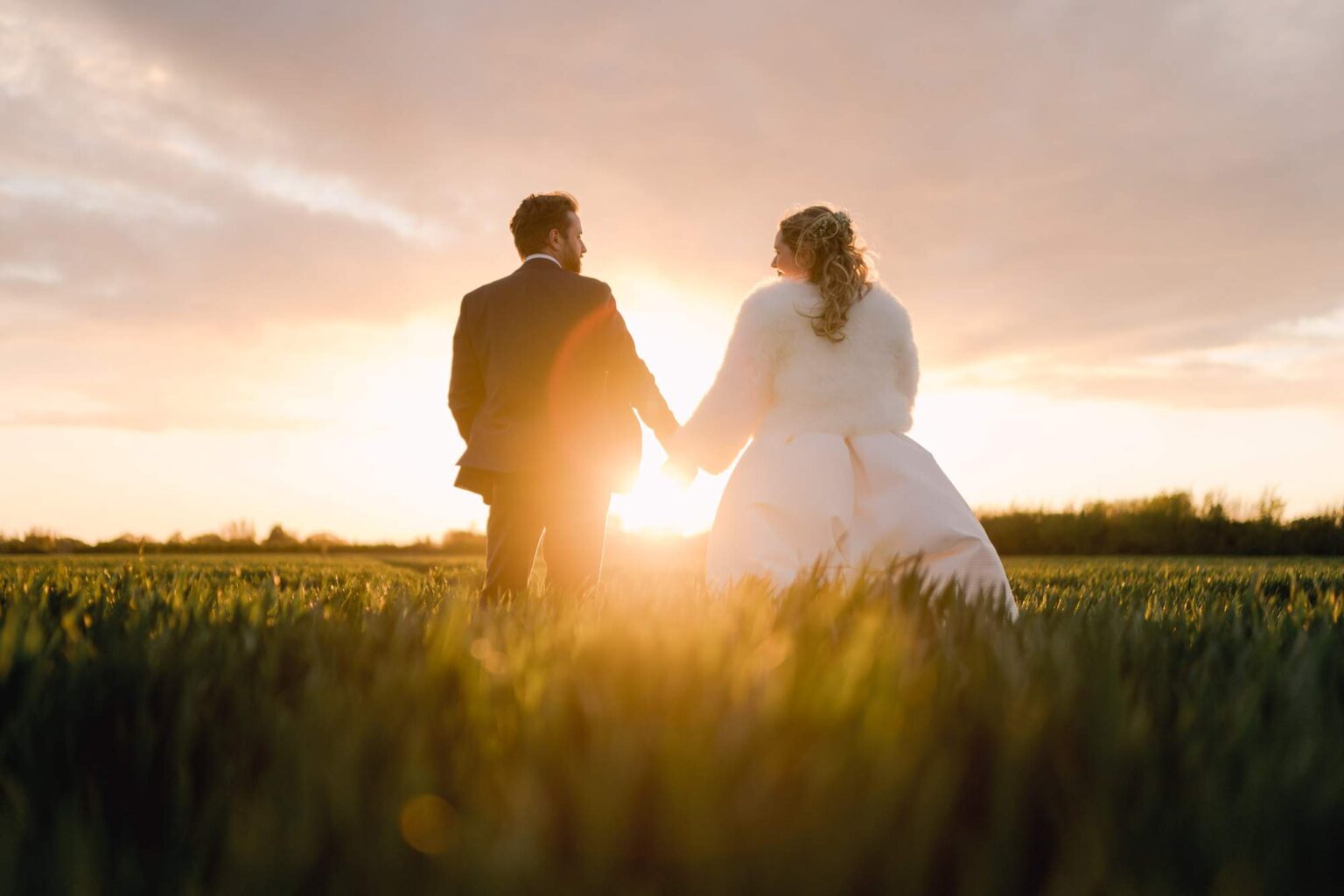 Bride and groom smiling whilst they take a stroll on their wedding day in Chichester.