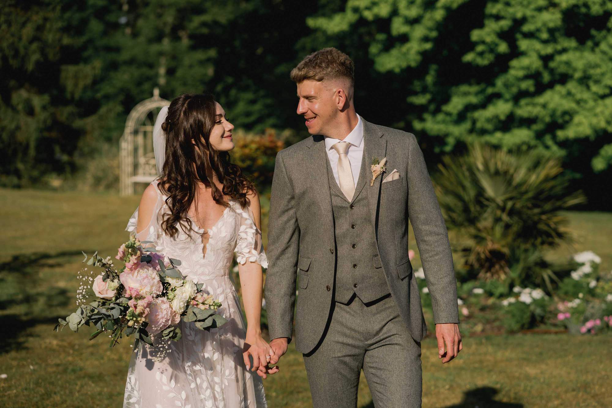 Bride and groom smiling whilst they take a stroll on their wedding day at Southdowns Manor Hotel.