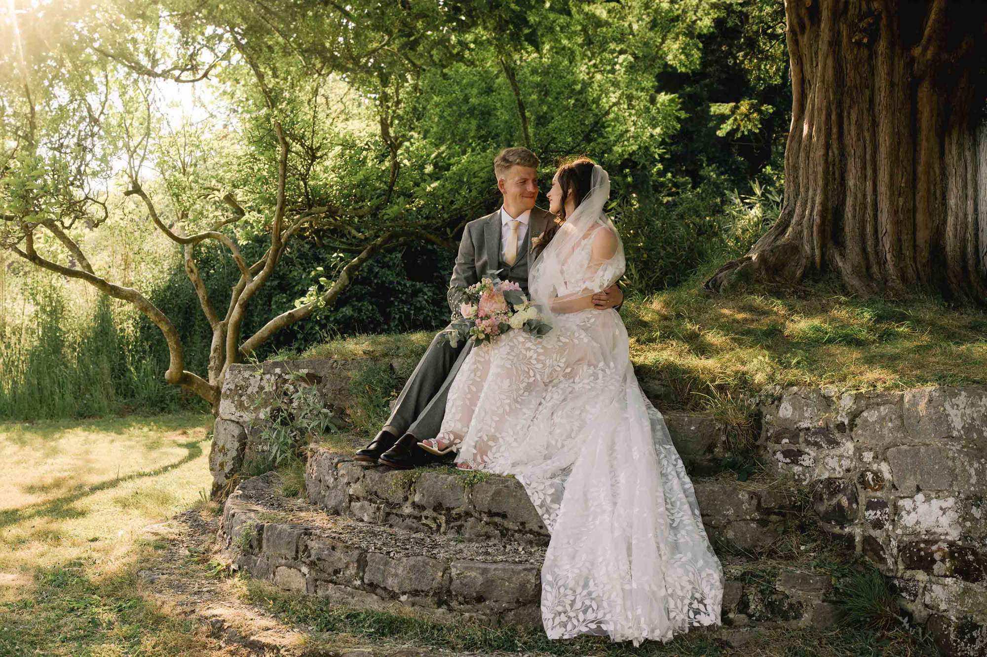Bride and groom hug closely on their sunny wedding day at Southdowns Manor in West Sussex.