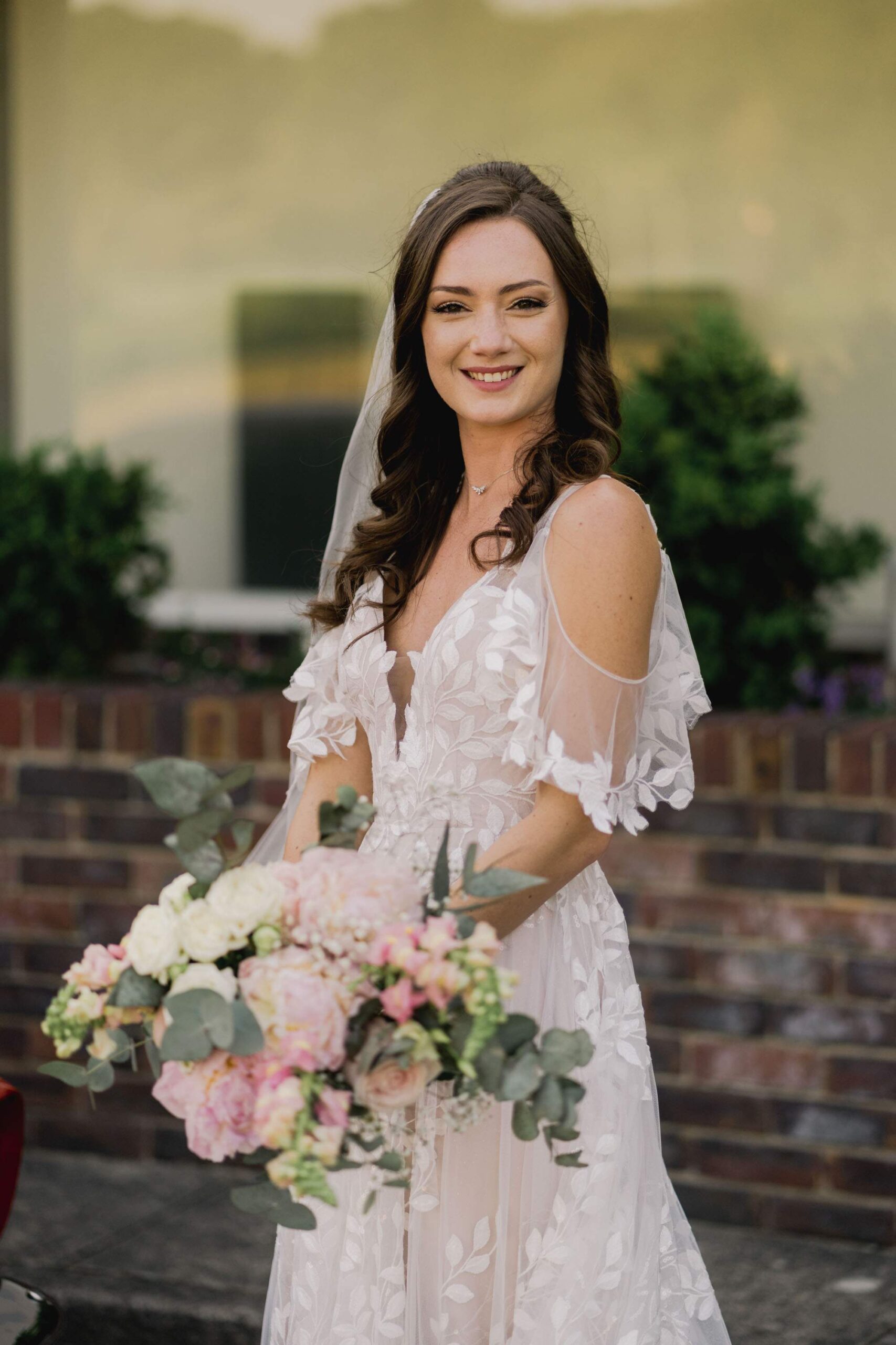 A beautiful bride holding her pink bouquet of flowers at Southdowns Manor.