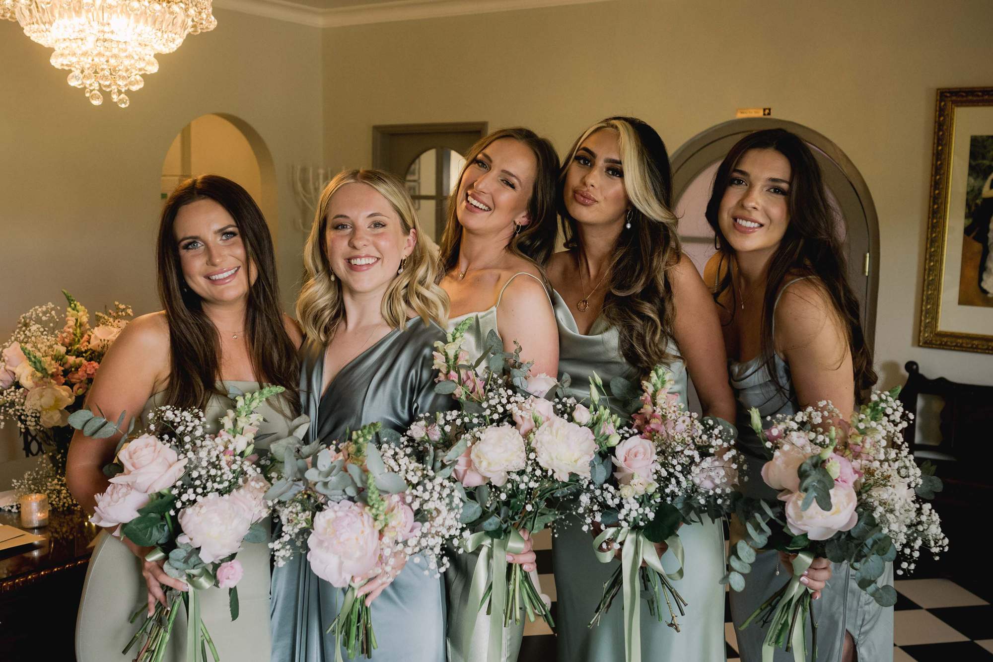The bridesmaids smile and laugh before the wedding ceremony.