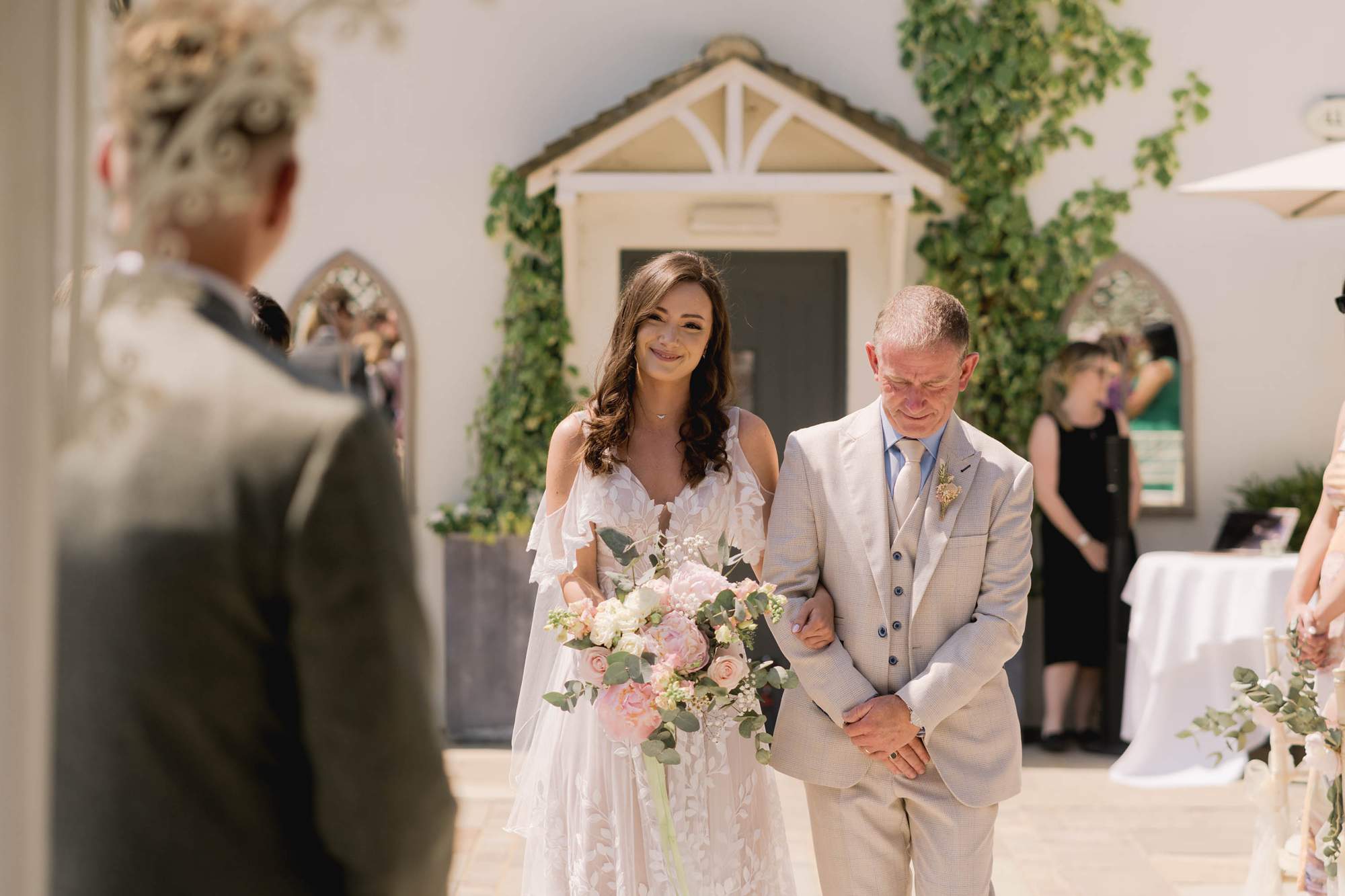 Bride walks down the aisle with her father on her wedding day.