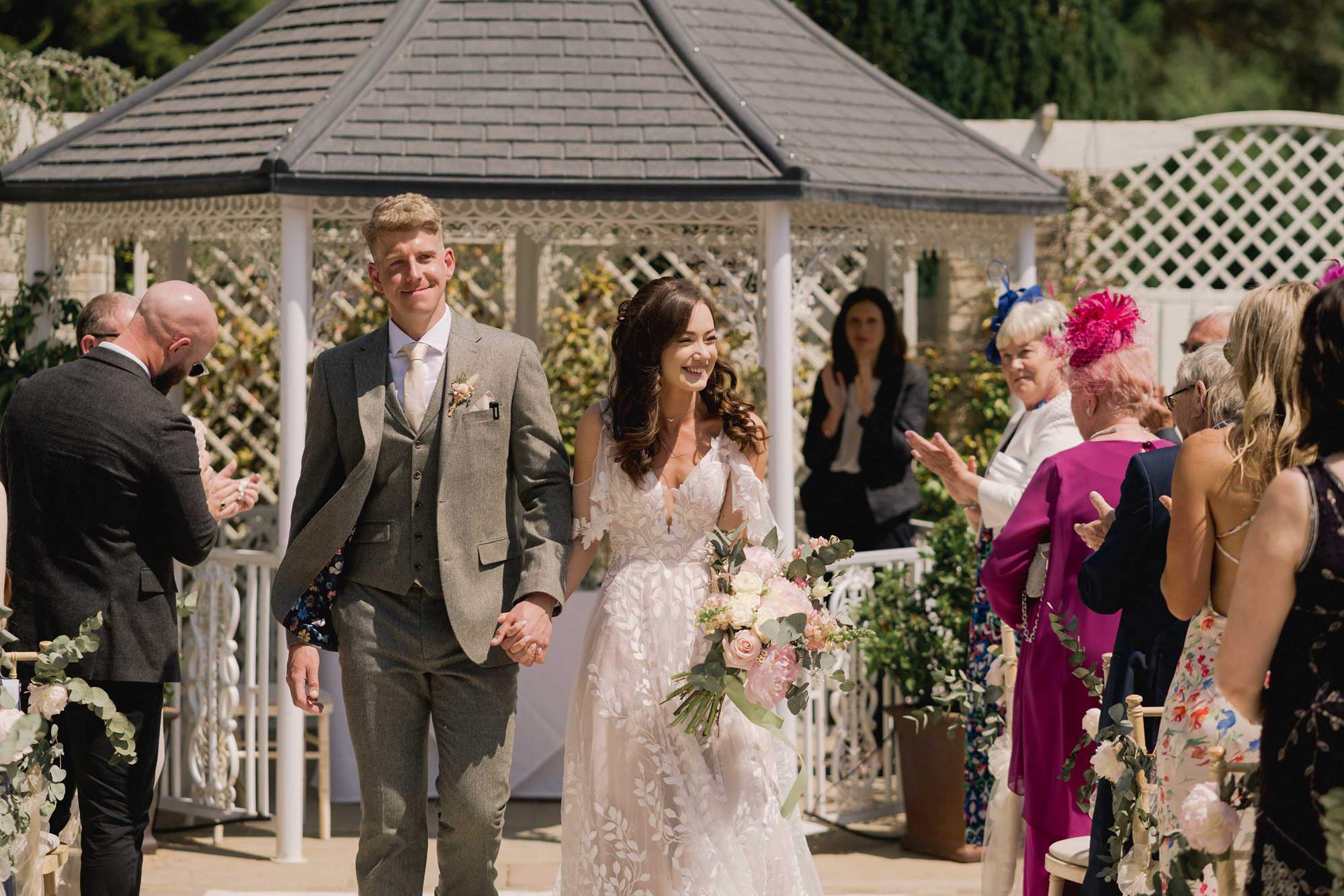 Bride and groom walk back up the aisle after their outdoor ceremony at Southdowns Manor in Sussex.