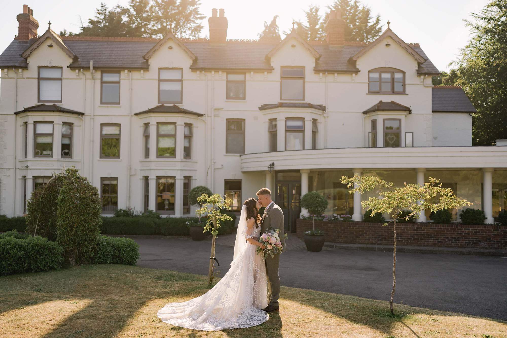 Bride and groom kiss on their wedding day at Southdowns Manor in West Sussex.