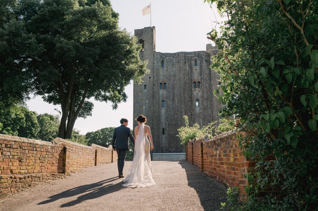 Bride and groom smiling whilst they take a stroll on their wedding day in Essex.